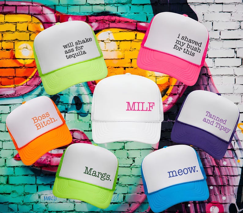 Puede incluir: Siete gorras de camionero de espuma con paneles frontales blancos y viseras de colores. El texto incluye: will shake ass for tequila, i shaved my bush for this, Boss Bitch., MILF, Tanned and Tipsy, Margs., y meow. en varios colores y estilos.