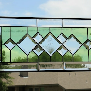 May include: A rectangular stained glass panel featuring a geometric pattern of clear and light green glass segments framed in black metal. The center diamond-shaped clear glass pane contains an etched silhouette of a rearing horse.
