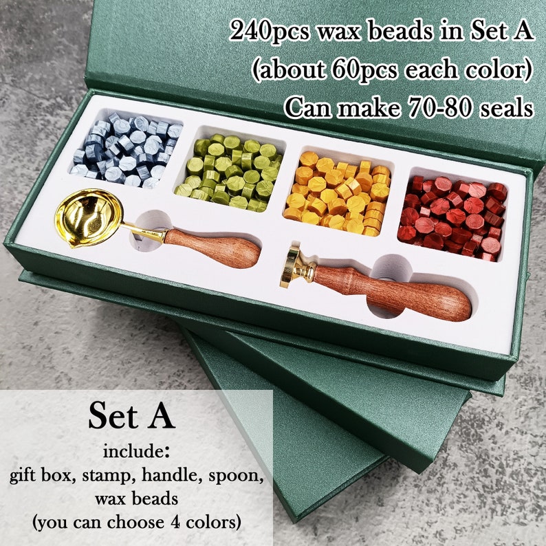 Peut inclure: Ensemble de fournitures de sceau de cire Set A dans une bo&icirc;te verte. L'ensemble comprend un tampon, une poign&eacute;e, une cuill&egrave;re et 240 perles de cire en quatre couleurs&nbsp;: argent, vert, or et rouge. Le texte sur la bo&icirc;te indique&nbsp;: &laquo;&nbsp;240pcs wax beads in Set A (about 60pcs each color) Can make 70-80 seals&nbsp;&raquo; et &laquo;&nbsp;Set A include: gift box, stamp, handle, spoon, wax beads (you can choose 4 colors)&nbsp;&raquo;