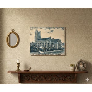 May include: A framed print of The Parish Church, Haverhill, England, in a vintage style. The print is displayed above a wooden shelf with a candle, a small dish, a succulent, and a framed portrait. A gold-framed mirror hangs on the wall.