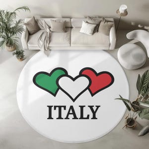 Könnte beinhalten: Runder weißer Teppich mit drei Herzen in den Farben der italienischen Flagge, grün, weiß und rot. Das Wort "ITALIEN" ist unter den Herzen gedruckt.
