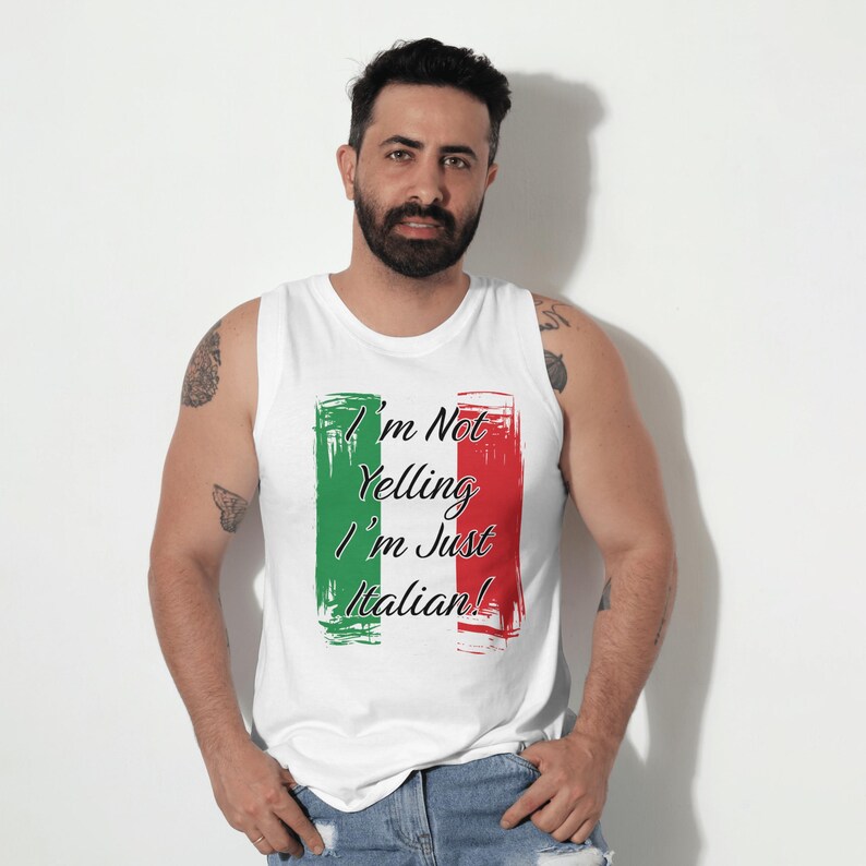 May include: White tank top with the text "I'm Not Yelling I'm Just Italian!" in black script. The text is framed by green and red brushstroke rectangles, resembling the Italian flag. The tank top is sleeveless.