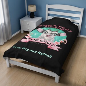 May include: Black twin bed sheet with a white goat wearing glasses and a pink ribbon that says "Greatest Nonna The Goat of All Time". The sheet also has the text "love, Trey and Hannah".