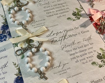 Puede incluir: Llavero de cuentas blancas con un dije de cruz y una tarjeta que dice "Love Plants the seed Faith Helps it Grow Growth in Faith "Que el Señor dé a sus ángeles la responsabilidad de cuidarte para guiarte en todos tus caminos." Salmo 91:11 Gracias Por celebrar con nosotros hoy! #vida_personalgrowth"