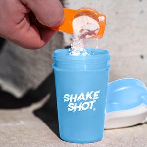 May include: A white ceramic mug with a black handle and the text "But first, coffee" in a black, handwritten-style font. The mug is on a white surface.