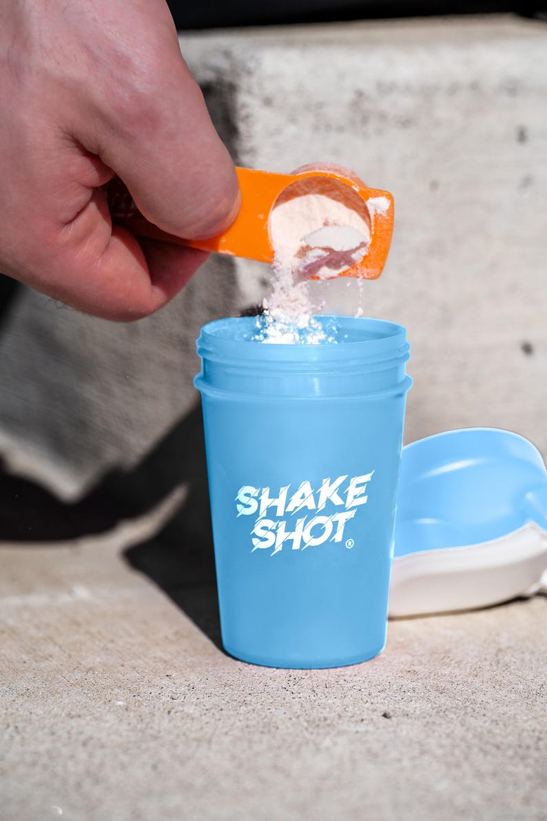 May include: A white ceramic mug with a black handle and the text "But first, coffee" in a black, handwritten-style font. The mug is on a white surface.