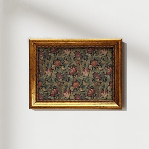 May include: A gold-colored picture frame with a floral pattern inside. The frame has a decorative border and a dark background.