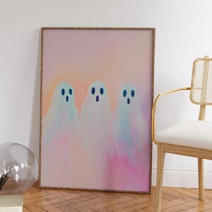 May include: A framed print of three pastel-colored ghosts with blue eyes on a pink and orange background.