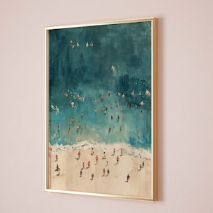 May include: A framed painting of an aerial view of a beach with people swimming and sunbathing in the turquoise water. The beach is white sand and the water is a vibrant blue.