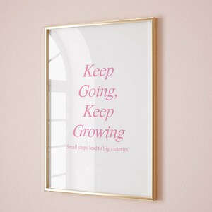 Puede incluir: Una impresi&oacute;n enmarcada en dorado con el texto "Keep Going, Keep Growing" y la leyenda "Small steps lead to big victories."