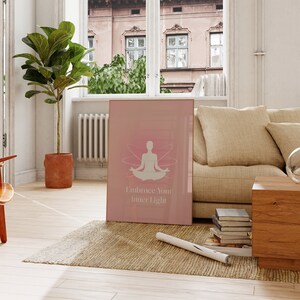 Puede incluir: Un p&oacute;ster rosa con una silueta blanca de una persona sentada en una postura de yoga con las manos en el regazo. El p&oacute;ster tiene el texto "Embrace Your Inner Light" en blanco.