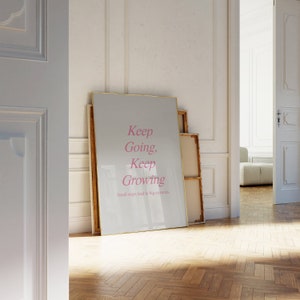 Puede incluir: Un p&oacute;ster motivacional enmarcado con fondo blanco y marco dorado. El texto "Keep Going, Keep Growing" est&aacute; escrito en cursiva rosa. El texto "Small steps lead to big victories" est&aacute; escrito en negro debajo del texto principal.