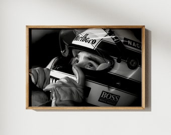 Op de afbeelding: Een zwart-wit ingelijste wandkunstprint met een autocoureur die een helm draagt met de tekst Marlboro, BOSS en NAC. De coureur draagt racehandschoenen en kijkt omhoog, waarbij het vizier van de helm gedeeltelijk omhoog staat.