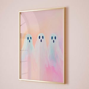 May include: A framed print of three pastel-colored ghosts with blue eyes on a pink and orange background.