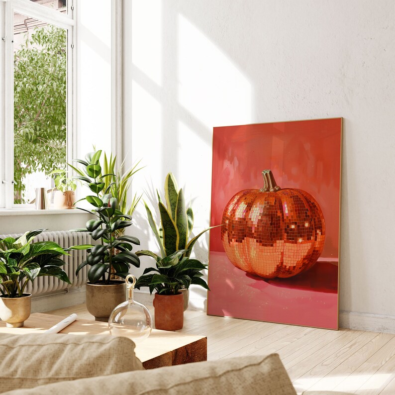 Pu&ograve; includere: Una stampa incorniciata di una grande zucca rossa a specchio su uno sfondo rosa. La zucca &egrave; fatta di piccole piastrelle riflettenti. La stampa &egrave; appesa a un muro bianco in una stanza con piante.