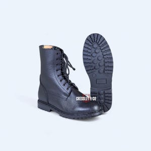 May include: Black leather combat boots with a lace-up design. The boots have a rugged sole and a mid-calf height. The brand name "CRESSLEY & CO" is visible on the side of the boot. The boots are approximately 10 inches tall.