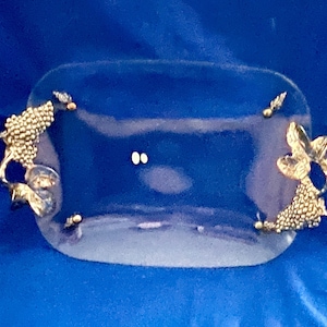 Könnte beinhalten: Ein Set aus drei Keramikbechern mit einer gesprenkelten, cremefarbenen Glasur. Jeder Becher hat ein anderes handgemaltes Design: ein blaues und grünes Blatt, eine gelbe und orangefarbene Blume und ein roter Beerenzweig. Die Becher haben eine einfache, abgerundete Form.