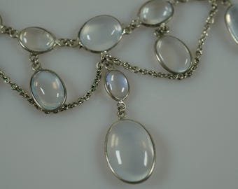 Puede incluir: Un collar de cadena de plata con cuentas de piedra lunar de forma ovalada. El collar tiene un colgante de gota con una cuenta de piedra lunar más grande.