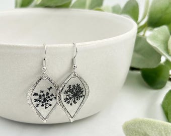 Pendiente de encaje negro con flores preservadas, joyería botánica de resina, accesorio de plata hecho a mano, diseño elegante, pieza llamativa inspirada en la naturaleza para graduación.