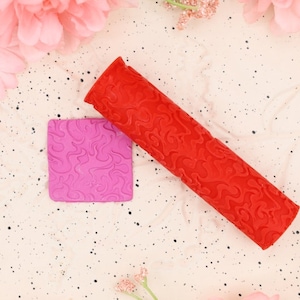 May include: Red and pink silicone rolling pins with a swirl pattern. The rolling pins are used for decorating cakes and pastries.