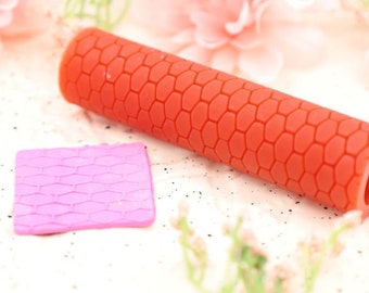 Può includere: Un mattarello in silicone rosso con un motivo a nido d'ape e un tappetino in silicone rosa più piccolo con lo stesso motivo.