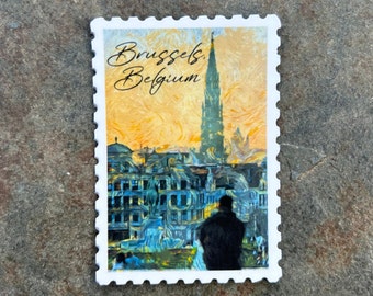 May include: A rectangular sticker with a postage stamp design featuring a cityscape of Brussels, Belgium. The image includes a tall spire, buildings, and a person. The text "Brussels, Belgium" is written in cursive.