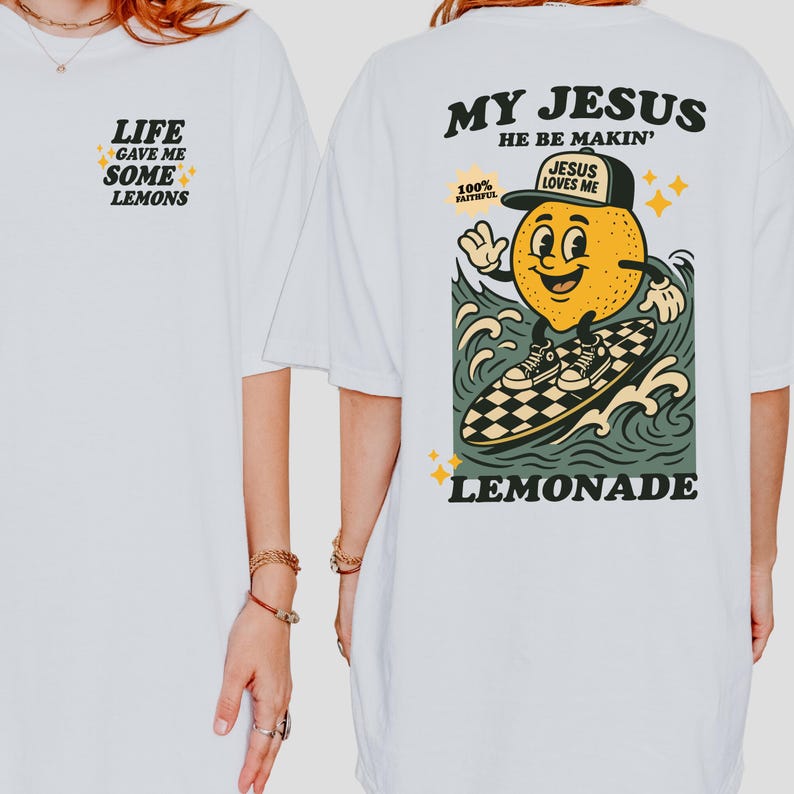 May include: White t-shirt with the text "LIFE GAVE ME SOME LEMONS" on the front. The back features a cartoon lemon surfing with the words "MY JESUS HE BE MAKIN'" and "LEMONADE". The lemon wears a hat that says "JESUS LOVES ME".