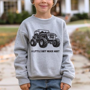 May include: A gray sweatshirt with a black graphic of a jeep with the text "A little dirt never hurt".