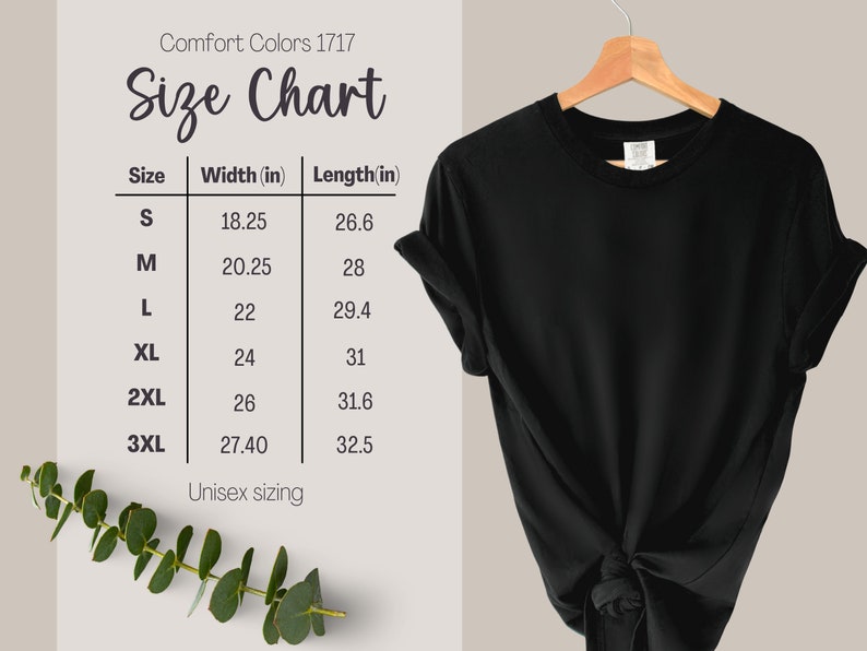 May include: A black t-shirt hanging on a wooden hanger, displayed next to a Comfort Colors 1717 size chart. The chart lists sizes S through 3XL with corresponding width and length measurements in inches. The shirt features a knotted hem at the bottom.