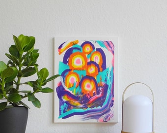 May include: Abstract painting on canvas with a colorful design of overlapping circles in shades of orange, yellow, pink, and blue. The background is white with hints of purple and turquoise.