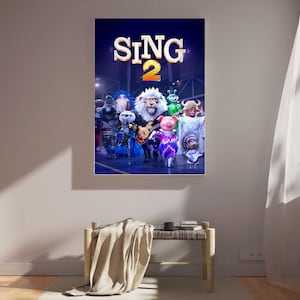 Könnte beinhalten: Ein gerahmtes Filmplakat für "Sing 2" mit einer Gruppe animierter Charaktere. Der Titel "SING 2" wird in großen, beleuchteten Buchstaben angezeigt. Zu den Charakteren gehören ein Löwe, ein Schwein und andere Tiere.