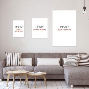 May include: Three blank white canvas prints of varying sizes are displayed on a wall above a gray sectional sofa. The sizes are 11"x17" (27.94 x 43.18 cm), 16"x24" (40.64 x 60.96 cm), and 24"x36" (60.96 x 91.44 cm).