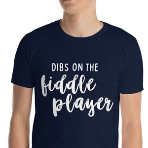 May include: A navy blue t-shirt with white text that reads "Dibs on the fiddle player".