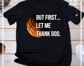 May include: Black t-shirt with a basketball graphic and the text "BUT FIRST... LET ME THANK GOD."