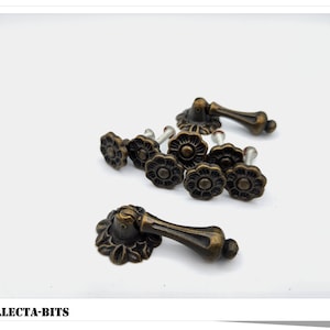 Pode incluir: Um conjunto de oito botões de armário de latão antigo com um design floral. Os botões têm uma pega decorativa e são perfeitos para adicionar um toque de charme vintage a qualquer casa.