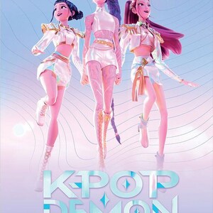 May include: An animated poster featuring three stylized female figures in white and gold outfits, with long hair in shades of blue and pink. The text "KPOP DEMON HUNTERS" is displayed in a teal font at the bottom of the image, set against a gradient background.
