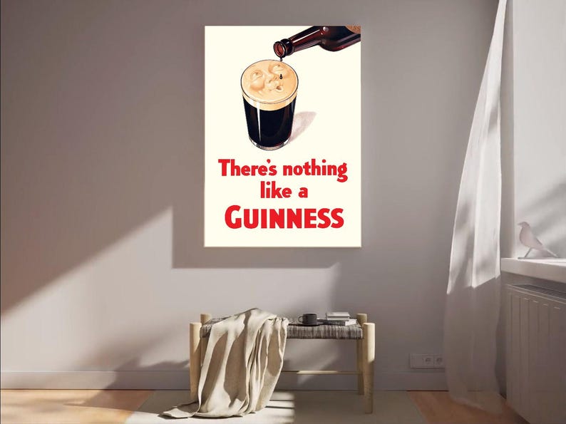 Puede incluir: Un cuadro enmarcado que muestra una pinta de Guinness que se est&aacute; sirviendo. El texto "There's nothing like a Guinness" est&aacute; en rojo. La obra de arte est&aacute; colgada en una pared sobre un banco.