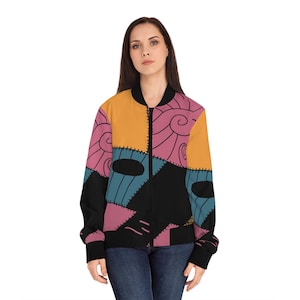 Könnte beinhalten: Bunte Bomberjacke mit Patchwork-Design in Orange, Rosa, Blau und Schwarz. Die Jacke hat einen Reißverschluss und schwarze gerippte Bündchen und Saum. Das Design ist von einer Figur aus einem beliebten Animationsfilm inspiriert.