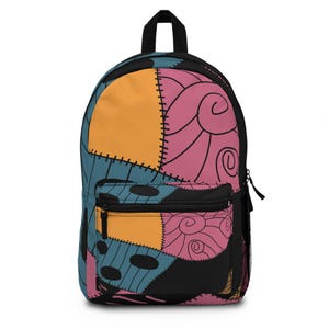 May include: A colorful backpack with a patchwork design featuring orange, blue, pink, and black panels. The backpack has a black zipper pocket, a top handle, and adjustable straps. The design is reminiscent of a stitched-together aesthetic.