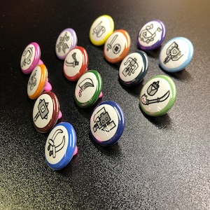 May include: A set of 12 colorful round pins with black and white illustrations of various weapons and tools. The pins are perfect for adding a touch of whimsy to your belongings.