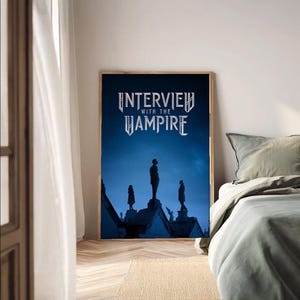 Könnte beinhalten: Ein gerahmtes Poster mit dem Titel "Interview with the Vampire" in einer stilisierten Schriftart. Das Poster zeigt Silhouetten von Figuren auf einem Dach vor einem dunkelblauen Himmel. Der Rahmen ist aus Holz.