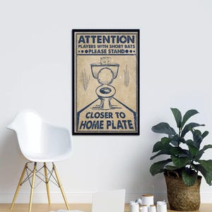 Könnte beinhalten: Ein gerahmtes Poster mit Vintage-Design. Das Poster zeigt ein blaues und beiges Farbschema mit dem Text "ATTENTION PLAYERS WITH SHORT BATS PLEASE STAND CLOSER TO HOME PLATE" und eine Toilettenillustration.