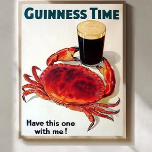 May include: A framed print featuring a pint of Guinness stout held by a red crab. The text "Guinness Time" is at the top, with "Have this one with me!" at the bottom. The artwork has a vintage, illustrative style.