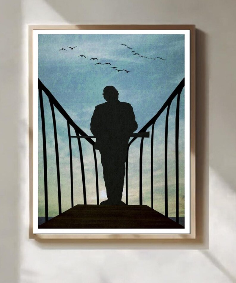 May include: Framed art print depicting a silhouette of a person on a wooden structure, gazing at a blue sky with birds in flight. The artwork has a minimalist style, creating a serene and contemplative atmosphere.