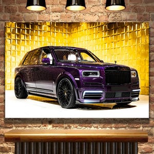 May include: A deep purple luxury SUV with a black grille and chrome accents. The car is parked on a white surface in front of a gold wall.