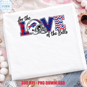 Puede incluir: Una camiseta blanca con un diseño gráfico que incluye el texto "for the LOVE of the Bills". La palabra "LOVE" está estilizada con un casco de fútbol americano que reemplaza la letra "O", con patrones rojos, blancos y azules de cuadros y puntos.