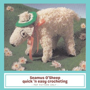 Puede incluir: Una figura de oveja tejida a ganchillo con un sombrero verde y una cinta naranja, sobre un fondo verde con flores blancas. La oveja tiene un aspecto esponjoso y texturizado. El texto "Seamus O'Sheep quick 'n easy crocheting" se muestra debajo.