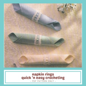 May include: Three rolled cloth napkins in pastel colors: blue, green, and cream. Each napkin is adorned with a white crocheted napkin ring. The image includes the text "napkin rings quick 'n easy crocheting - PDF PATTERN ONLY -."