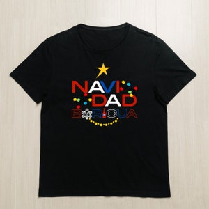 Peut inclure: T-shirt noir avec un motif d'arbre de Noël représentant les mots "NAVIDAD BORICUA" en lettres colorées et une étoile jaune en haut.