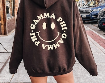 Gamma Phi Beta Smiley Schwesternschaft Sweatshirt | Trendy GPhi Custom Sorority Hoodie | Erhältlich in Braun Schwarz Grün Blau & Pink